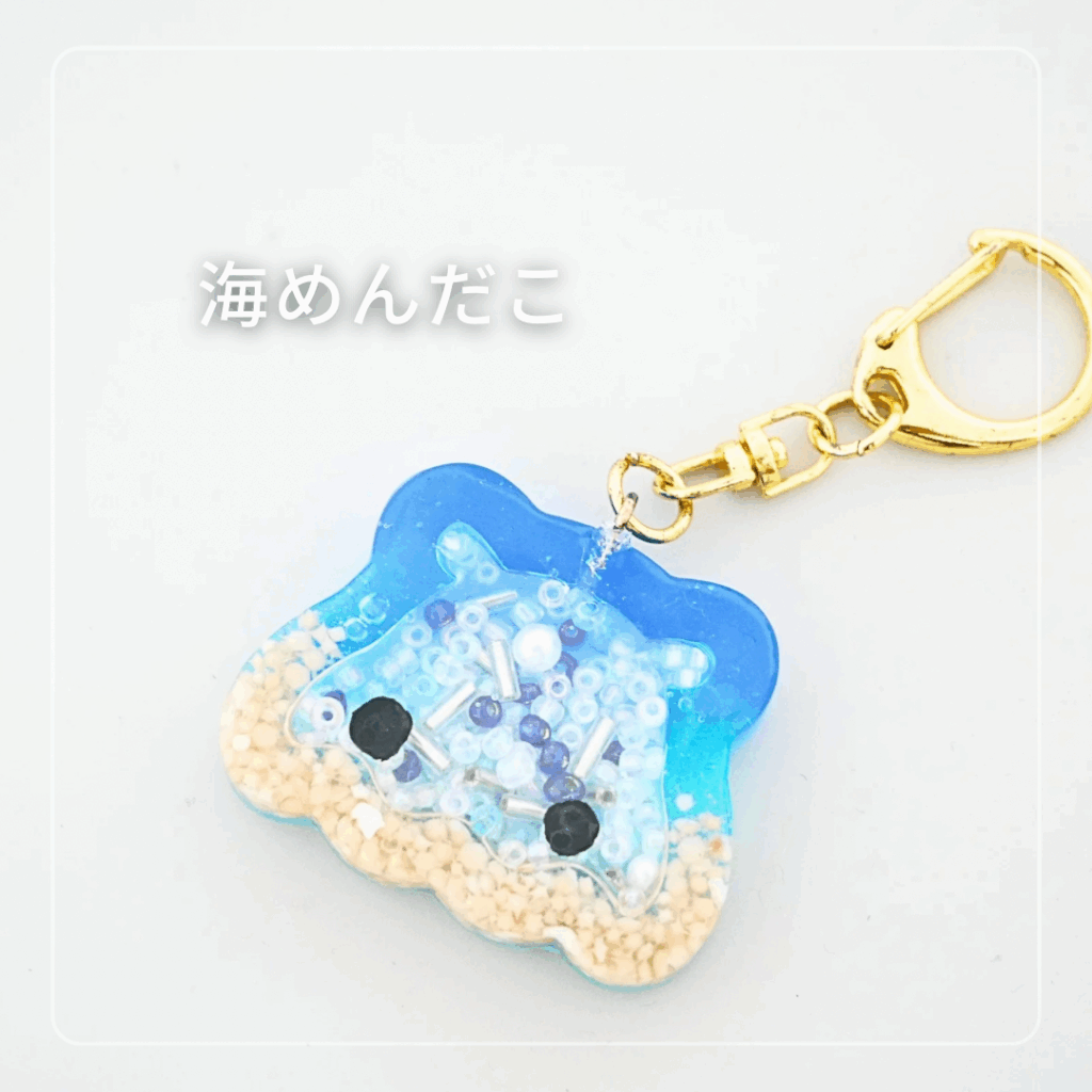 海と砂浜をイメージした青いレジンのめんだこチャーム