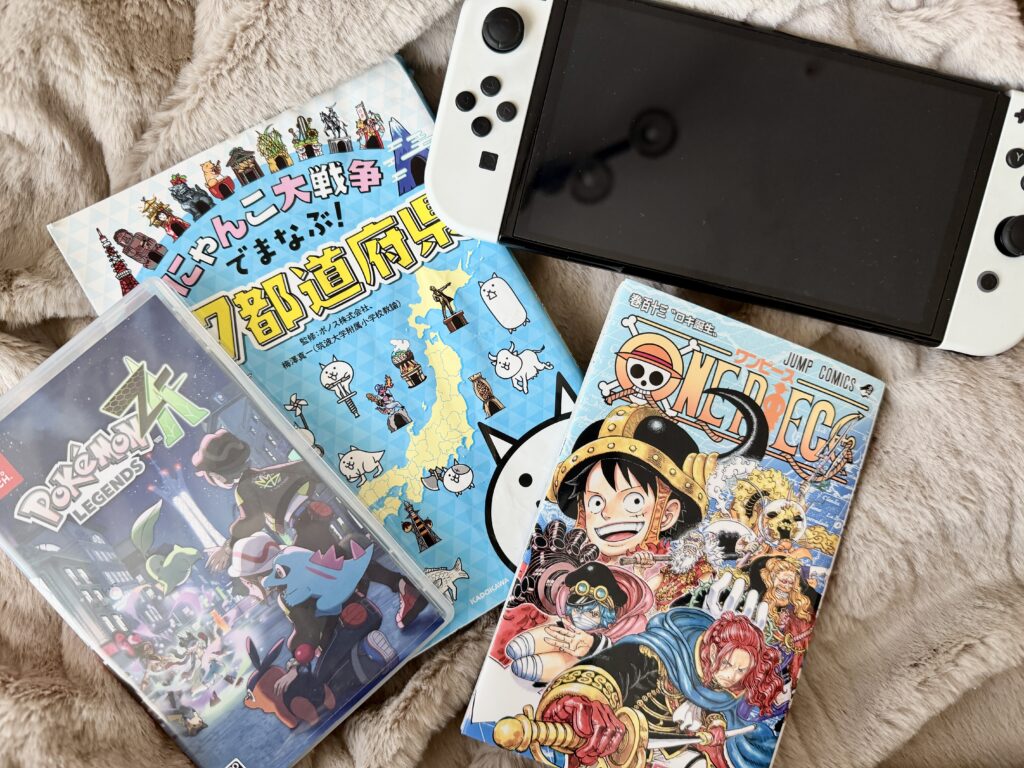 小学生高学年の男の子に人気のプレゼント:Switch、ポケモンのゲーム、ワンピース、学習本のにゃんこ大戦争が並んだ写真