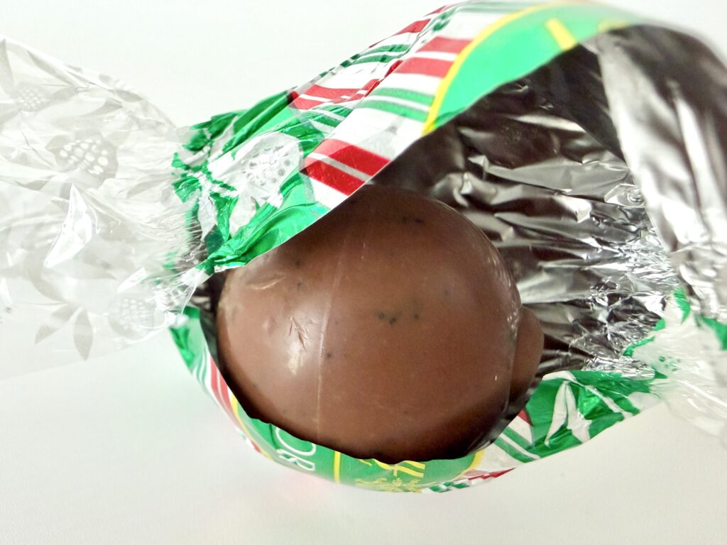 リンツ ペパーミントクッキーを包みを開封したところ。中から丸いチョコミントチョコが見える