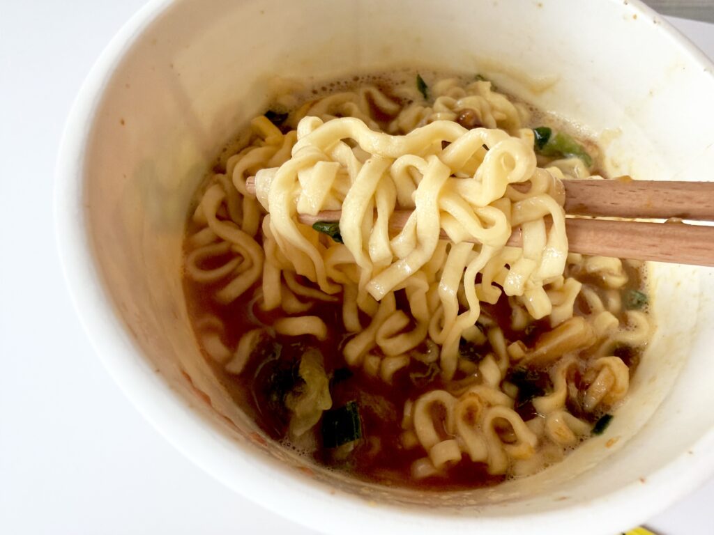 カレーみそきんの麺を箸で持ち上げた様子