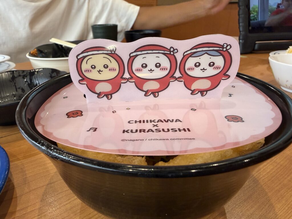 タコの衣装を着たちいかわ、ハチワレ、うさぎが描かれたくら寿司コラボメニューのカバー