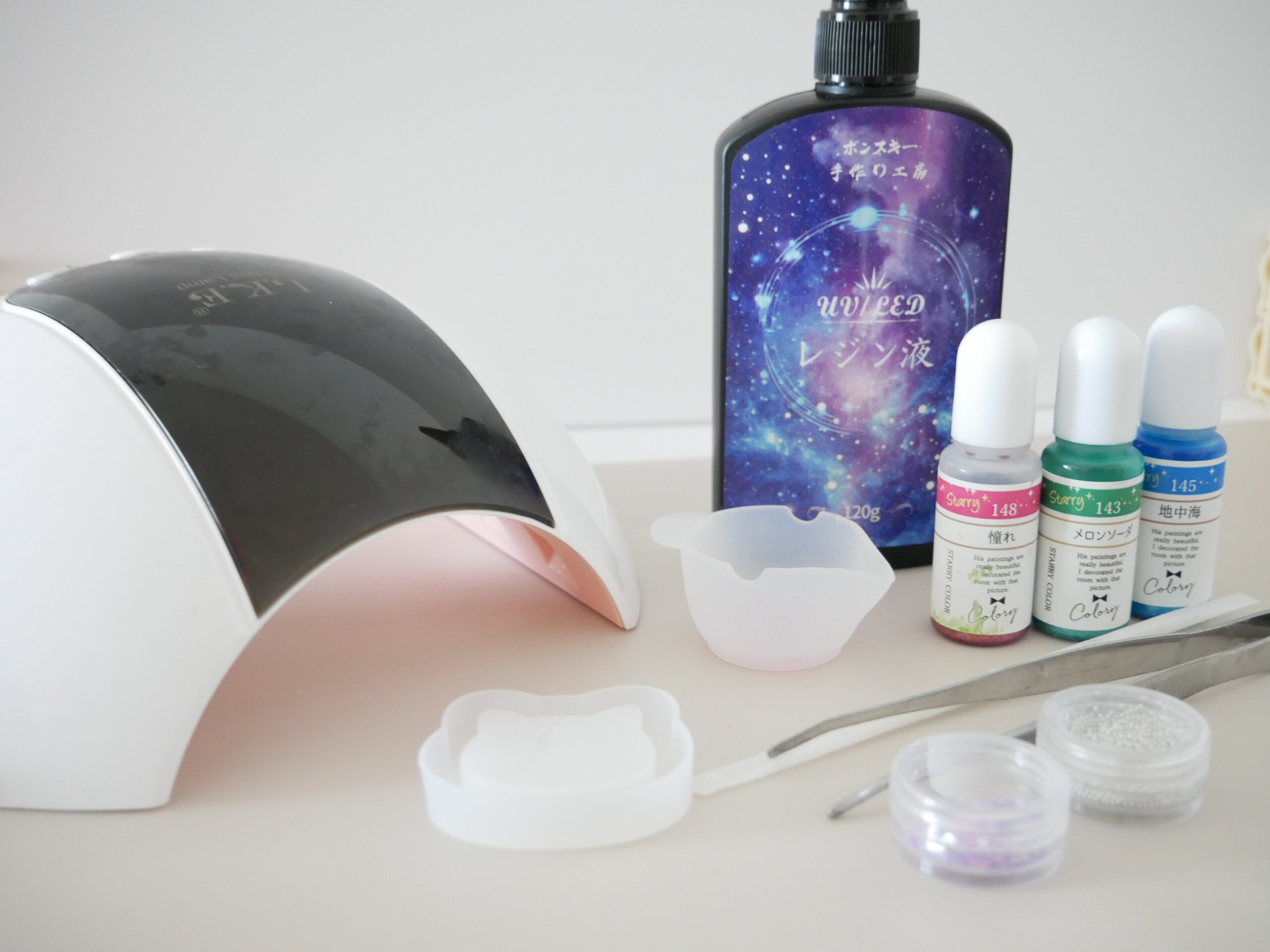 Basic resin tools including UV-LED resin, coloring agents, UV lamp, tweezers, and molds